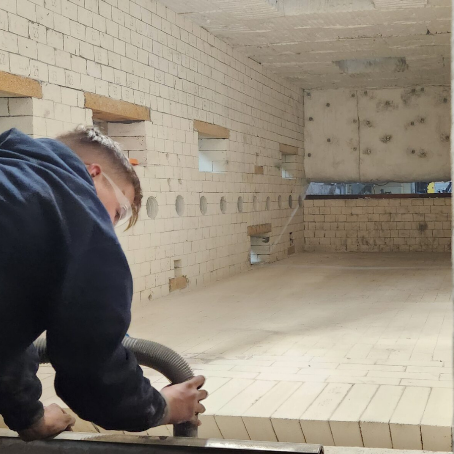 An Empire Solutions team member cleans up a furnace lined with firebrick.