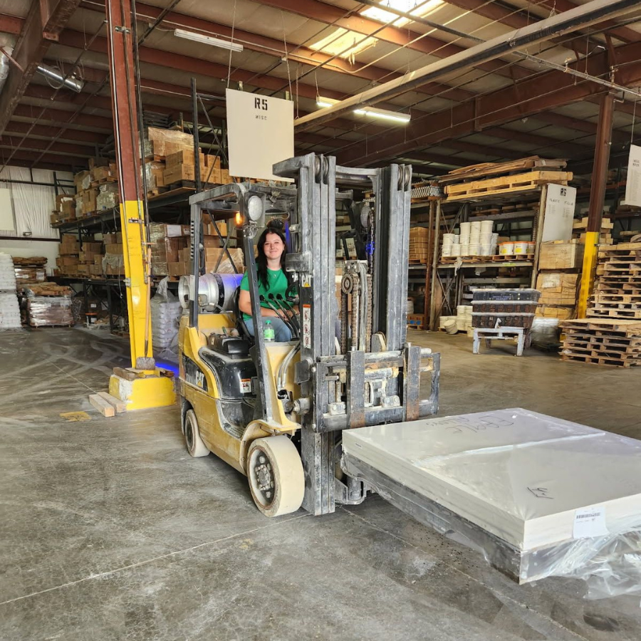 An Empire Solutions team member drives a forklift.