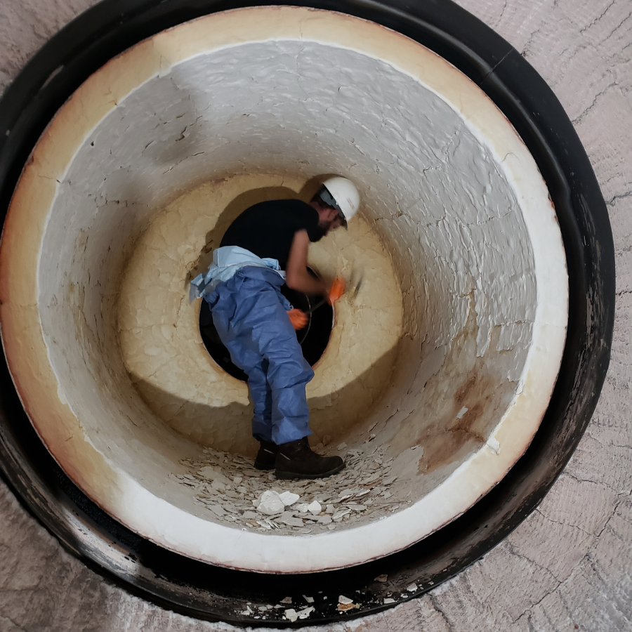 An Empire Solutions team member works to remove old lining within a furnace.